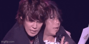 two men are standing next to each other on a stage .