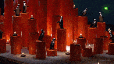 a bunch of orange candles with penguins on top