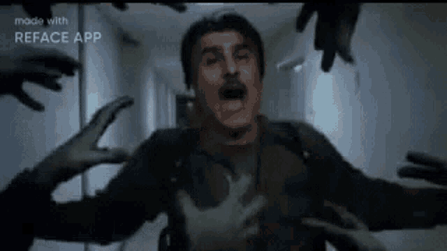 a man is being attacked by zombies in a hallway in a movie .