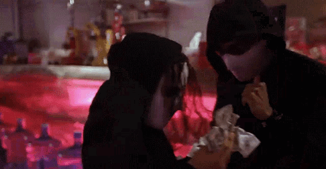 a man in a mask is giving a woman money