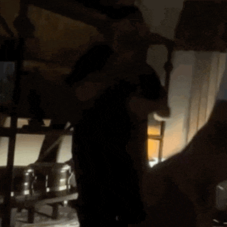 a person is standing in a dark room with a lamp on