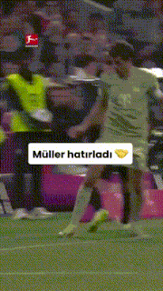 a soccer player is kicking a ball on a field with a sign that says muller hatirladi