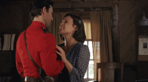 a man in a red uniform kissing a woman with the name andrew coppin on the bottom right