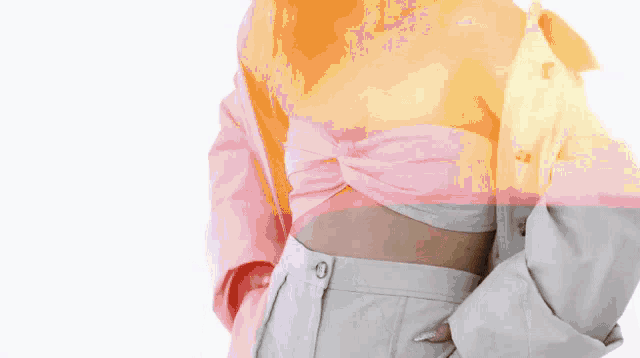 a woman wearing a white crop top and a white jacket is standing in front of a white background .