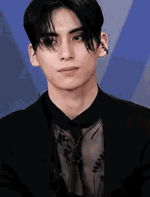 a close up of a man wearing a black suit and tie .
