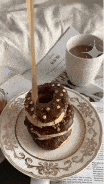 a plate with a donut on it and a cup of coffee