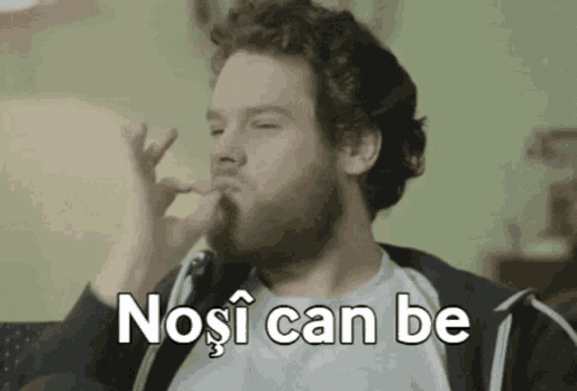 a man with a beard is sitting on a couch with his finger in his nose and the words nose can be written above him .