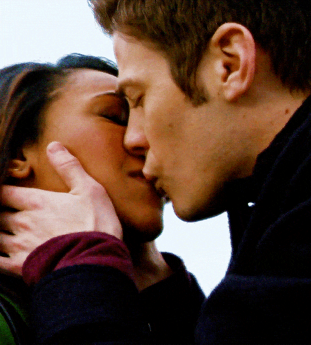 a close up of a man kissing a woman 's forehead