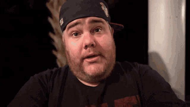 a man with a beard wearing a black shirt and a hat that says ' chicago ' on it