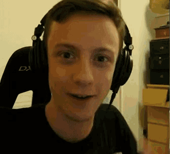a man wearing headphones with a dx logo on the back of his chair