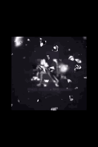 a bunch of diamonds are flying in the air on a black background .