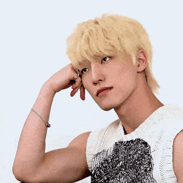 a man with blonde hair is wearing a black and white sweater vest