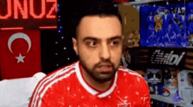 a man in a red shirt is making a funny face in front of a display of toys .