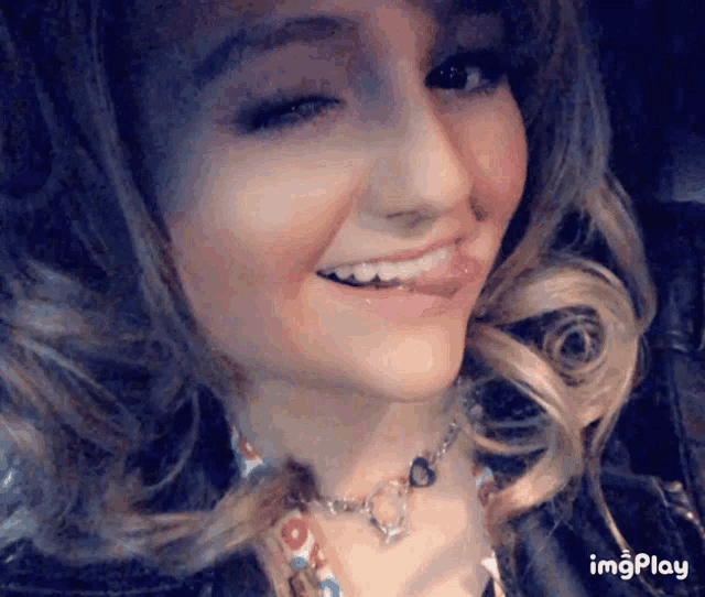 a close up of a woman 's face with the words imgplay at the bottom right