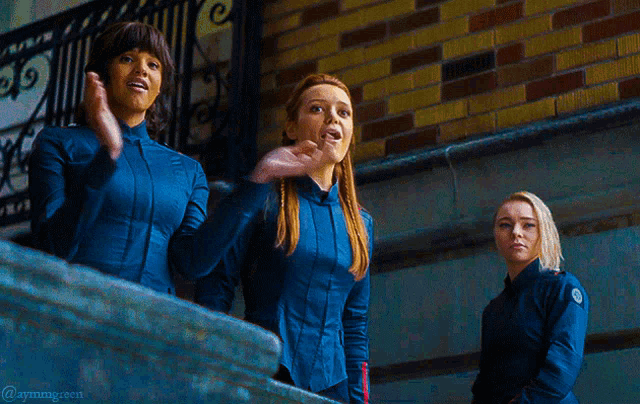 three women in blue uniforms are standing in front of a brick wall with the hashtag @ayningcorn