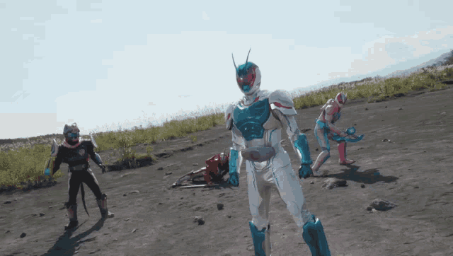 three kamen riders are standing on a dirt field with chinese writing