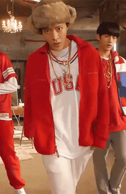 a man wearing a red jacket and a white shirt with the word usa on it