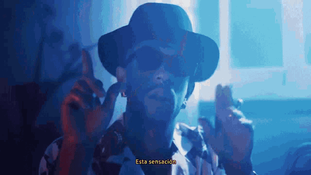 a man wearing a hat and sunglasses says " esta sensacion " in spanish