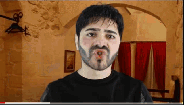 a man with a beard is making a funny face in front of a stone wall