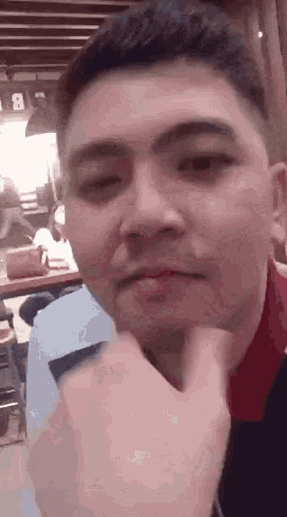 a man is making a funny face while sitting at a table .