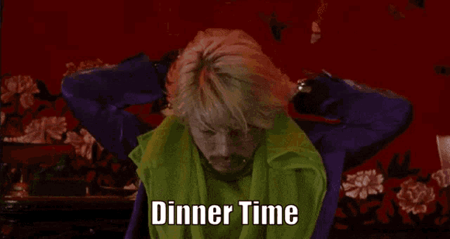 a man with blonde hair and a beard says dinner time in front of a red background