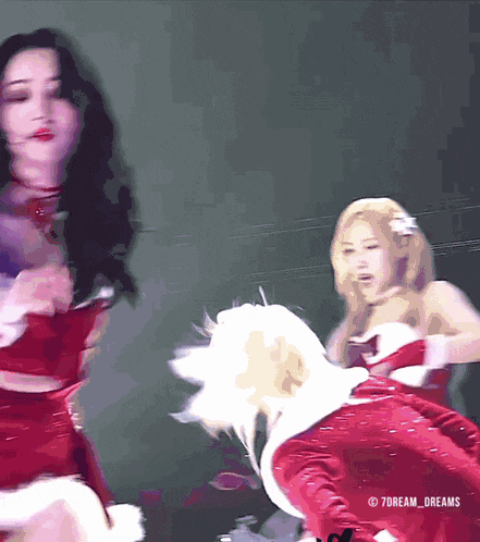 a woman in a santa costume is dancing on stage