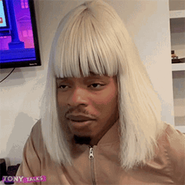 a man is wearing a blonde wig and a pink jacket .