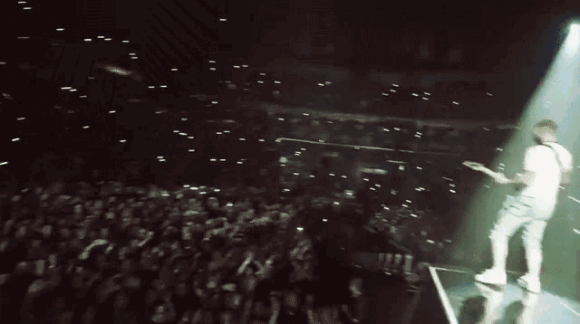 a man stands on a stage in front of a crowd