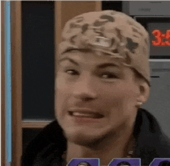 a man wearing a camo hat is making a funny face while looking at the camera .