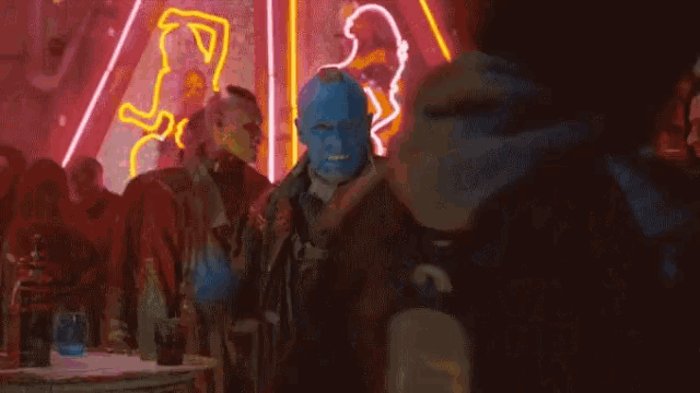 a man in a blue mask is standing in front of a crowd of people and says `` you can go to hell , then '' .