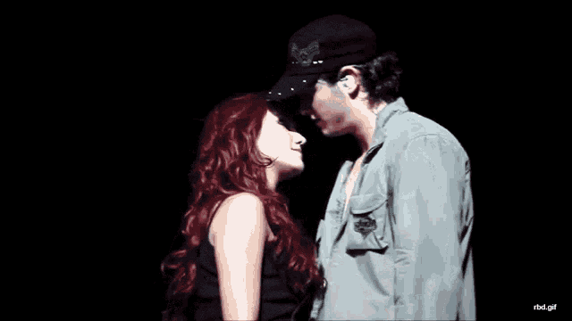 a man and a woman are looking into each other 's eyes with a black background that says rbd.gif