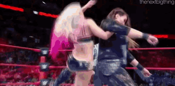a man and a woman are wrestling in a ring .