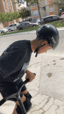 a person wearing a tsx helmet rides a scooter