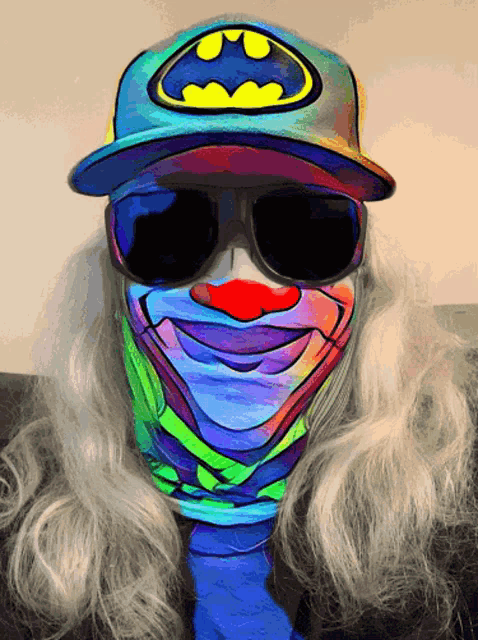 a clown wearing sunglasses and a hat with a batman logo on it