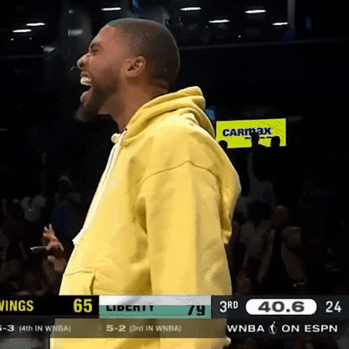 a man in a yellow hoodie is standing in front of a screen that says carimax