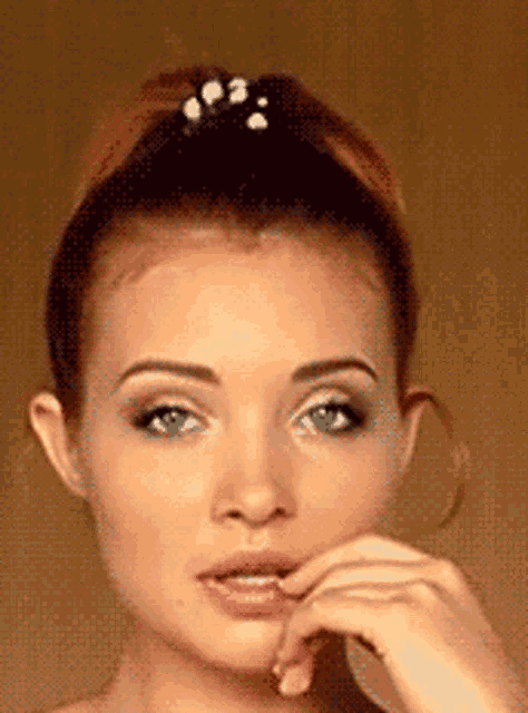 a close up of a woman 's face with a bun on her head