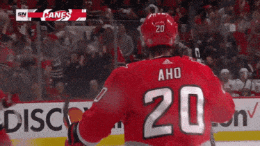 a hockey player wearing a red jersey with the number 20 on it