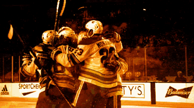 a hockey player with the number 23 on his jersey is hugging another player