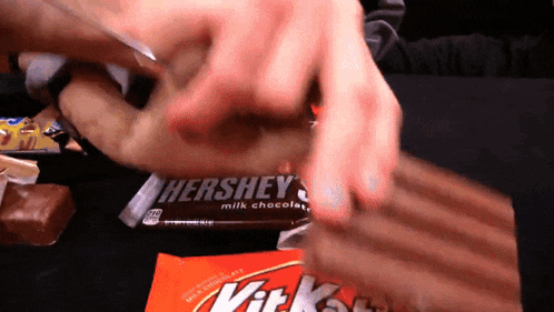 a person is opening a hershey 's kit kat bar