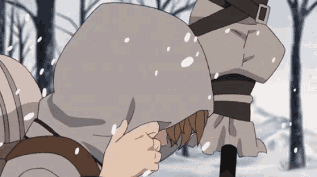 a person in a hooded jacket is holding another person 's arm in the snow