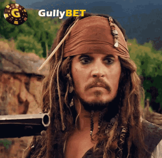 a man with dreadlocks and a bandana on his head stands in front of a sign that says gullybet