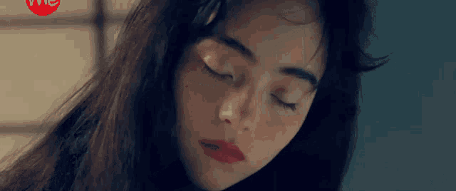 a close up of a woman with her eyes closed .