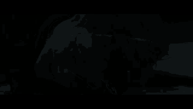 a bald man with his mouth open is screaming in a dark room