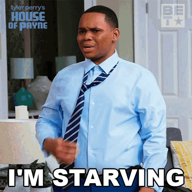 a man wearing a blue shirt and tie says " i 'm starving "