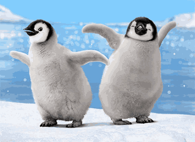 two baby penguins are dancing in the snow
