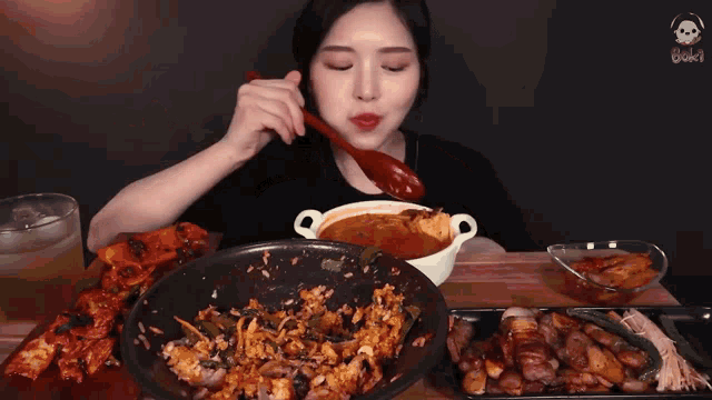 a woman is eating food with chopsticks and a bowl of soup