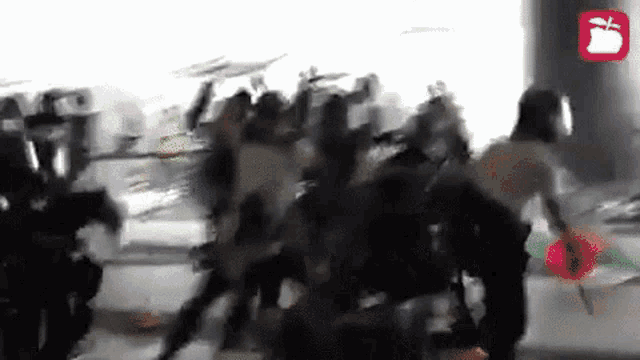 a group of people are fighting each other in a crowded room .