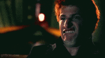 a man with red hair is making a funny face while holding a flashlight .