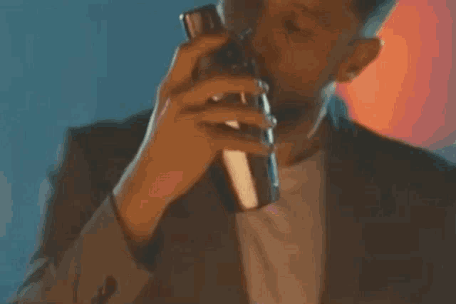 a man in a suit drinks from a shaker