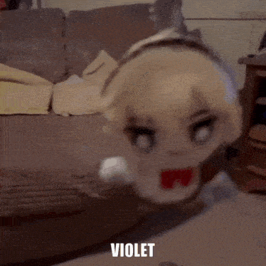 a stuffed toy of a girl with blonde hair is sitting on a couch .